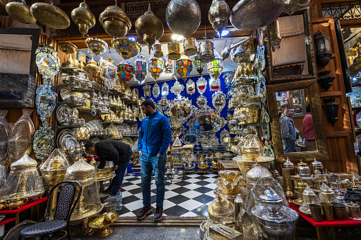 Fez, Morocco - January 01, 2024: View of a Moroccan handicraft shop, with the typical openwork metal, copper or brass lanterns, in the alleys of the renovated souk in the medina of Fes, Morocco