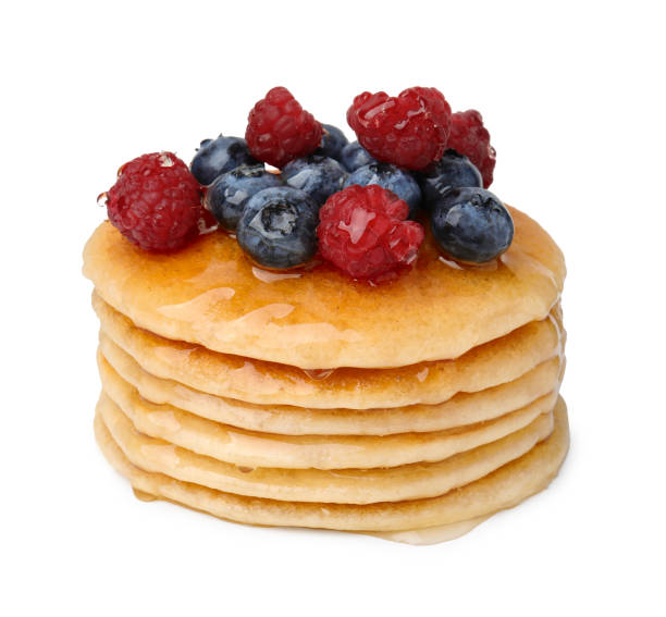 istock Stack of tasty pancakes with berries and honey isolated on white 1950276035
