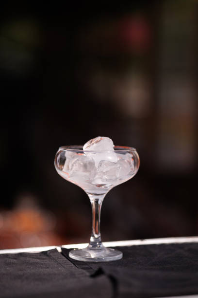 istock Ice-filled cocktail glass on elegant bar counter. 1950281846