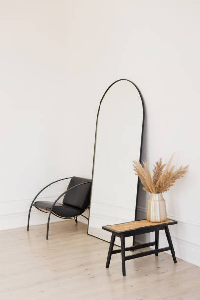 istock Stylish black mirror near white wall 1950303636