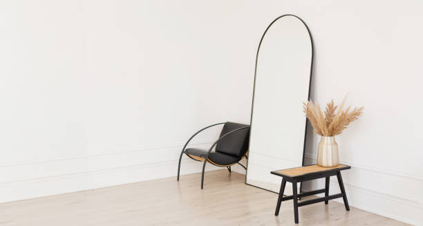 istock Stylish black mirror near white wall 1950303640