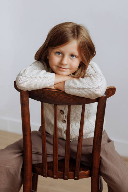 istock Child sitting on wooden chair. 1950341000