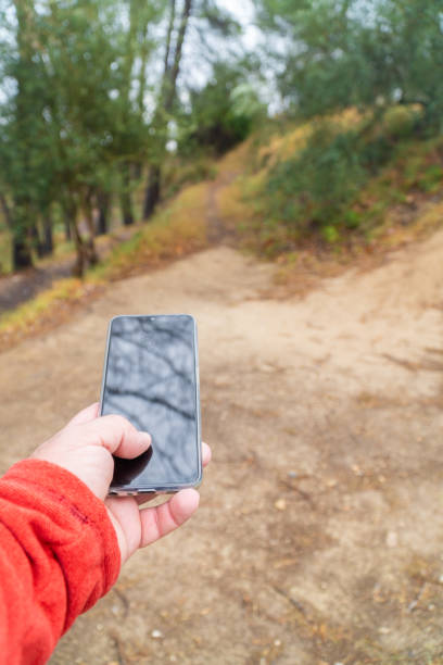 istock male hand with smartphone, outdoors in the forest 1950392833