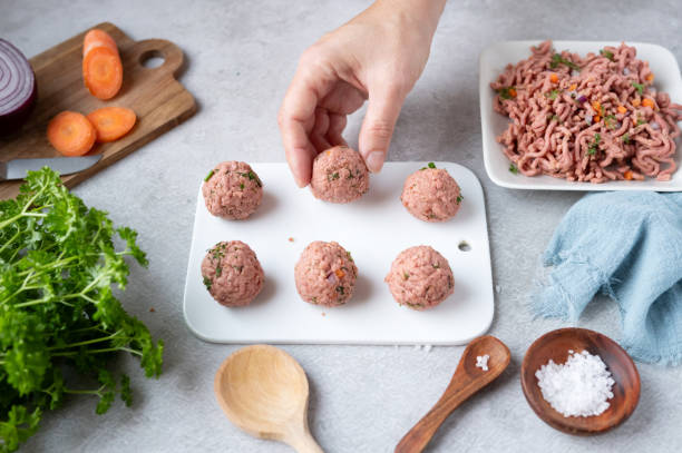 istock Female hand taking meat balls from minced plant-based meat. 1950400400