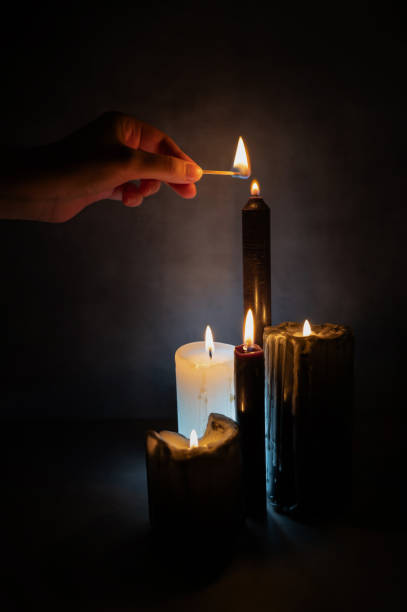istock Female hand lighting black candles for a magical occult ritual. 1950400521