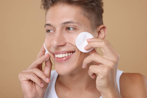 istock Handsome man with cotton pads on beige background 1950444981