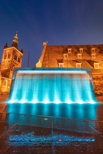 Gdansk, Poland - September 7 2023: Beautiful Hevelius fountain highlighted by colorful lights around and splashing water around at dark afternoon