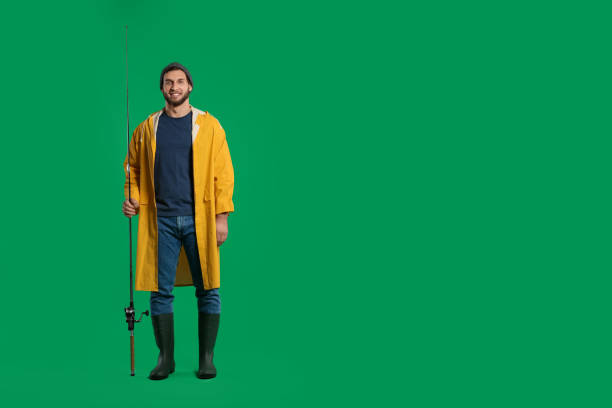 Fisherman with fishing rod on green background, space for text