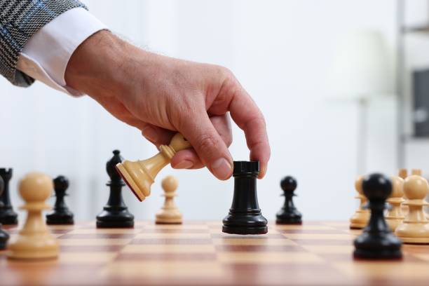 istock Man with rook game piece playing chess at checkerboard indoors, closeup 1950602585
