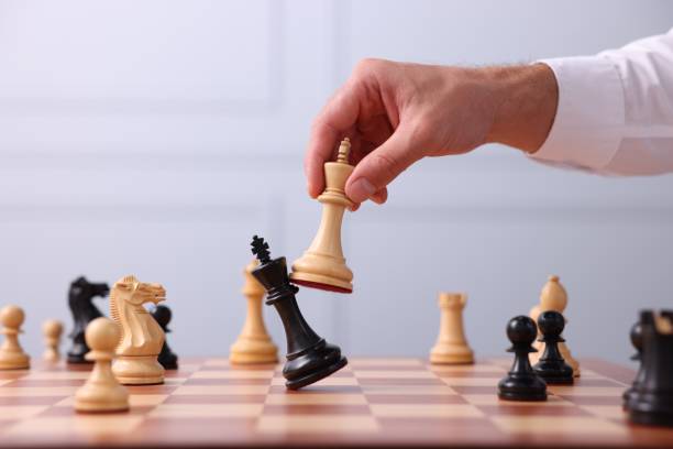 istock Man moving king chess piece at checkerboard indoors, closeup 1950603115