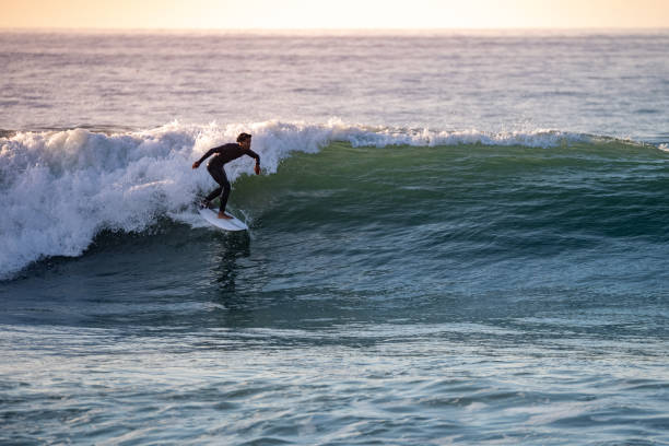 istock Sporty boy riding his surf board 1950605289