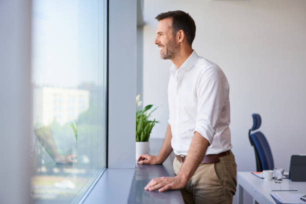 istock Businessman looking out the window in modern office 1950614234