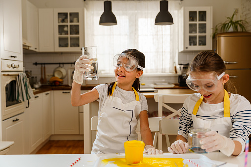 Two girls having fun making experiments with dishsoap and colors