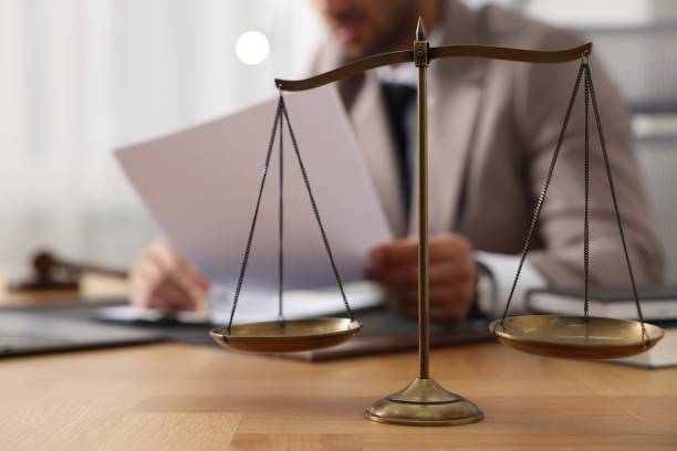 istock Lawyer working with document at table in office, focus on scales of justice 1950623192