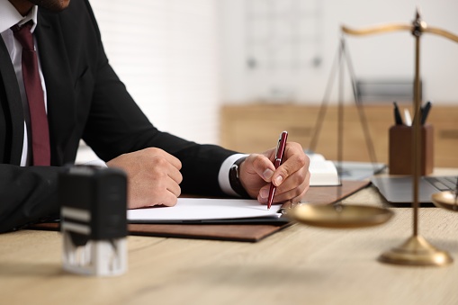 Lawyer working at table in office, selective focus