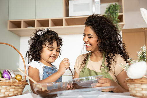 Mother and daughter making chocolate eggs for Easter