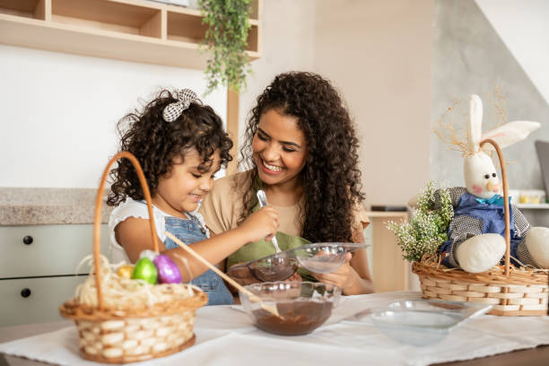 mother and daughter making chocolate eggs for easter - happy easter bildbanksfoton och bilder