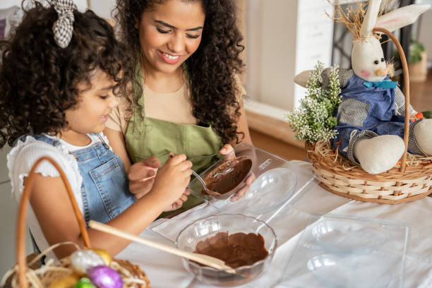 mother and daughter making chocolate eggs for easter - child easter egg home improvement easter imagens e fotografias de stock