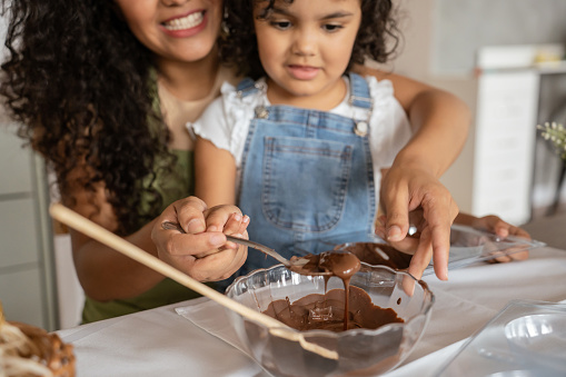 Mother and daughter making chocolate eggs for Easter