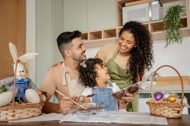 family with a daughter making chocolate for easter - easter easter egg child chocolate foto e immagini stock