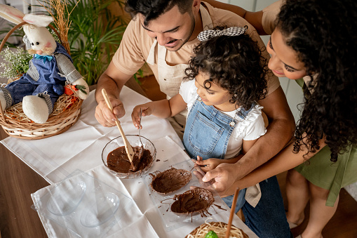 Family with a daughter making chocolate for Easter