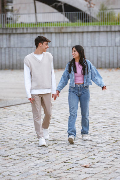 istock Young couple holding hands and walking together 1950635832