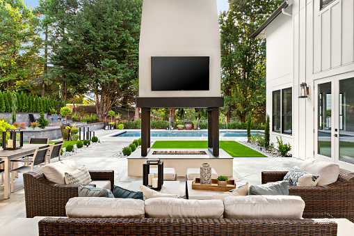 luxury home exterior with covered patio and pool