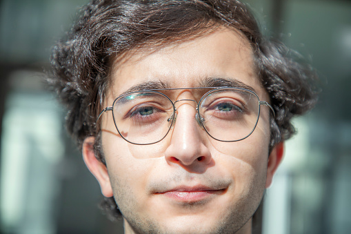Portrait of a young man with glasses and green eyes