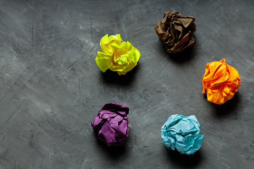 Crumpled Colorful Paper Balls on Gray Concrete, Concept of Uselessness and Worthlessness
