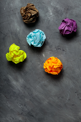 Crumpled Colorful Paper Balls on Gray Concrete, Concept of Uselessness and Worthlessness
