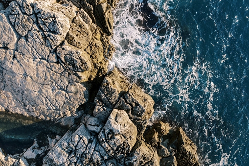 Sea surf hits the high rocky shore. Drone. High quality photo