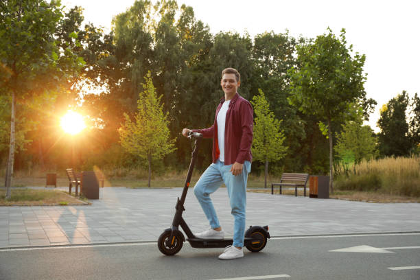istock Happy man with modern electric kick scooter in park 1950782603