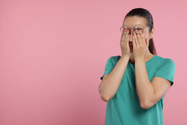 istock Resentful woman covering face with hands on pink background. Space for text 1950784662