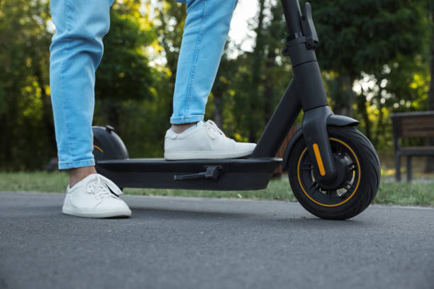 istock Man with modern electric kick scooter in park, closeup 1950784678