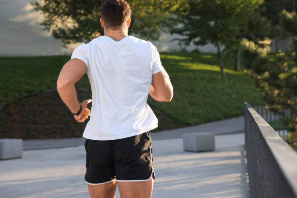 istock Man running outdoors on sunny day, back view 1950839373