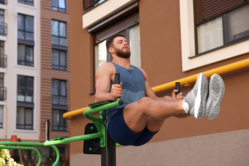 Man doing leg rise exercise at outdoor gym