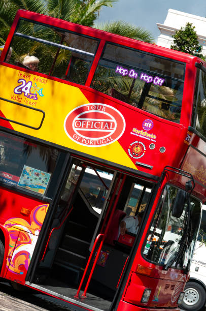 12th March, 2011 - Funchal: This image showcases a tourist bus navigating the vibrant streets of Funchal, filled with eager sightseers. The bus, a symbol of the city's thriving tourism, winds through the bustling roads, offering a glimpse of Funchal's lively urban landscape. The tourists, engaged and excited, represent the diverse visitors drawn to the city's charm and history.