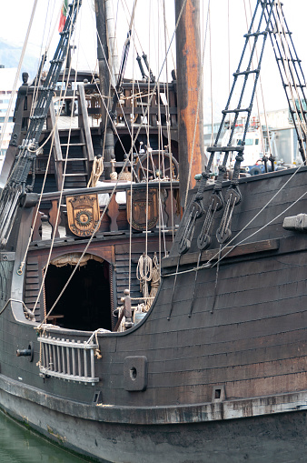 12th March, 2011 - Funchal, Madeira: In the heart of Funchal's vibrant harbour, a tourist pirate ship offers a unique spectacle against the modern backdrop of the city. Decked in traditional pirate aesthetics, the ship is a bustling hub of activity, with its crew and tourists mingling on deck. The workers, dressed in thematic attire, add to the authenticity of the experience, while the tourists, captivated by the novelty, eagerly explore the ship. The contrast between the old-world charm of the pirate ship and the contemporary surroundings of Funchal’s marina highlights the city's blend of history and modernity.