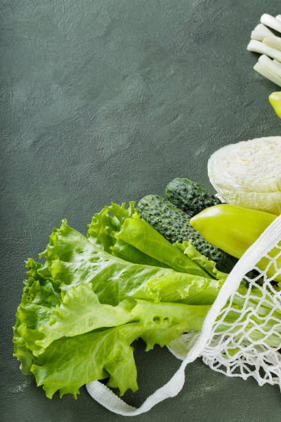 istock Fresh Green Vegetables in Mesh Bag on Green Background, Copy Space 1950886260