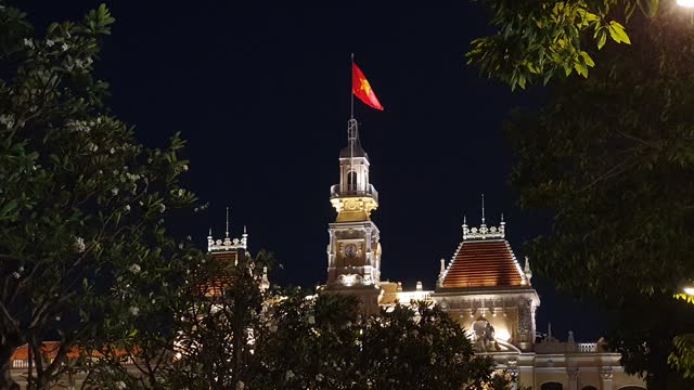 Night view of Ho Chi Minh city hall or people 's committee with uncle Ho statue