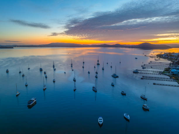 istock Sunrise over the water with boats and reflections 1950903607