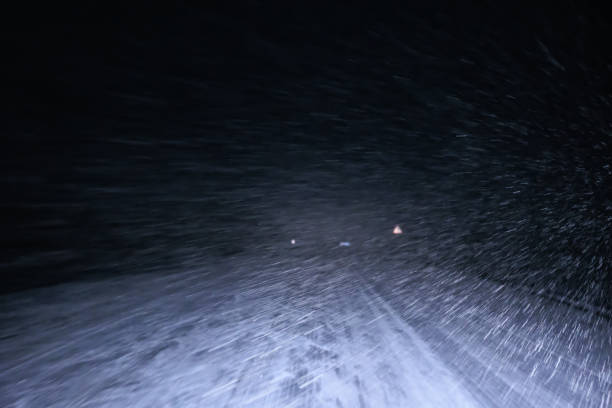 Blizzard on a country road at night in winter