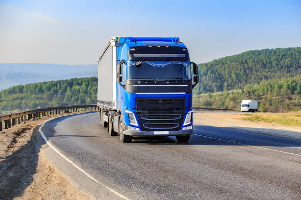 istock Trucks move along winding mountain road 1950913777