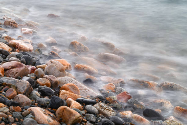 close up on pebble beach with sea wave slow motion