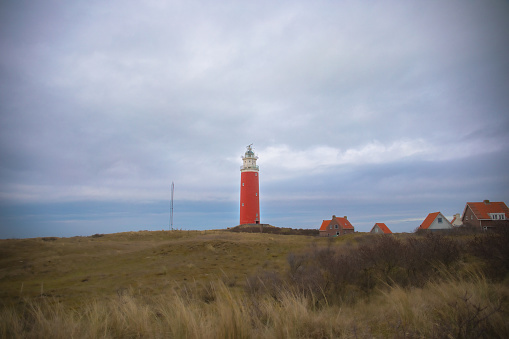 Lighthouse Near the Beach Texel, Nethernalds.\nApril 2023, cloudy weather with grass view