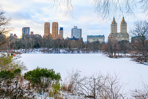 Winter view at Upper West Side cityscape buildings at sunset from Central Park New York City lake