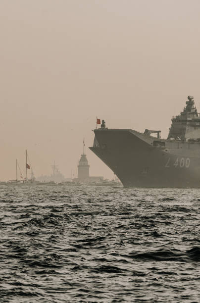 Sun sets over the enchanting city of Istanbul, Turkey, a modern warship gracefully navigates the Bosphorus Strait. Against the backdrop of the mesmerizing Istanbul skyline