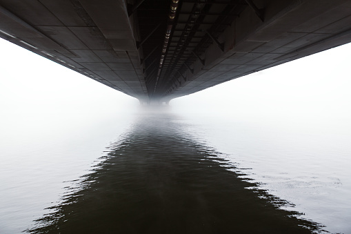 River view under the bridge in the foggy morning