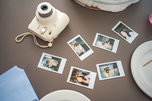 A collection of Polaroid photos displayed in a beautifully table at baby shower.