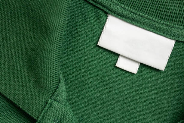 istock Blank white laundry care clothes label on green shirt fabric texture background 1951039057